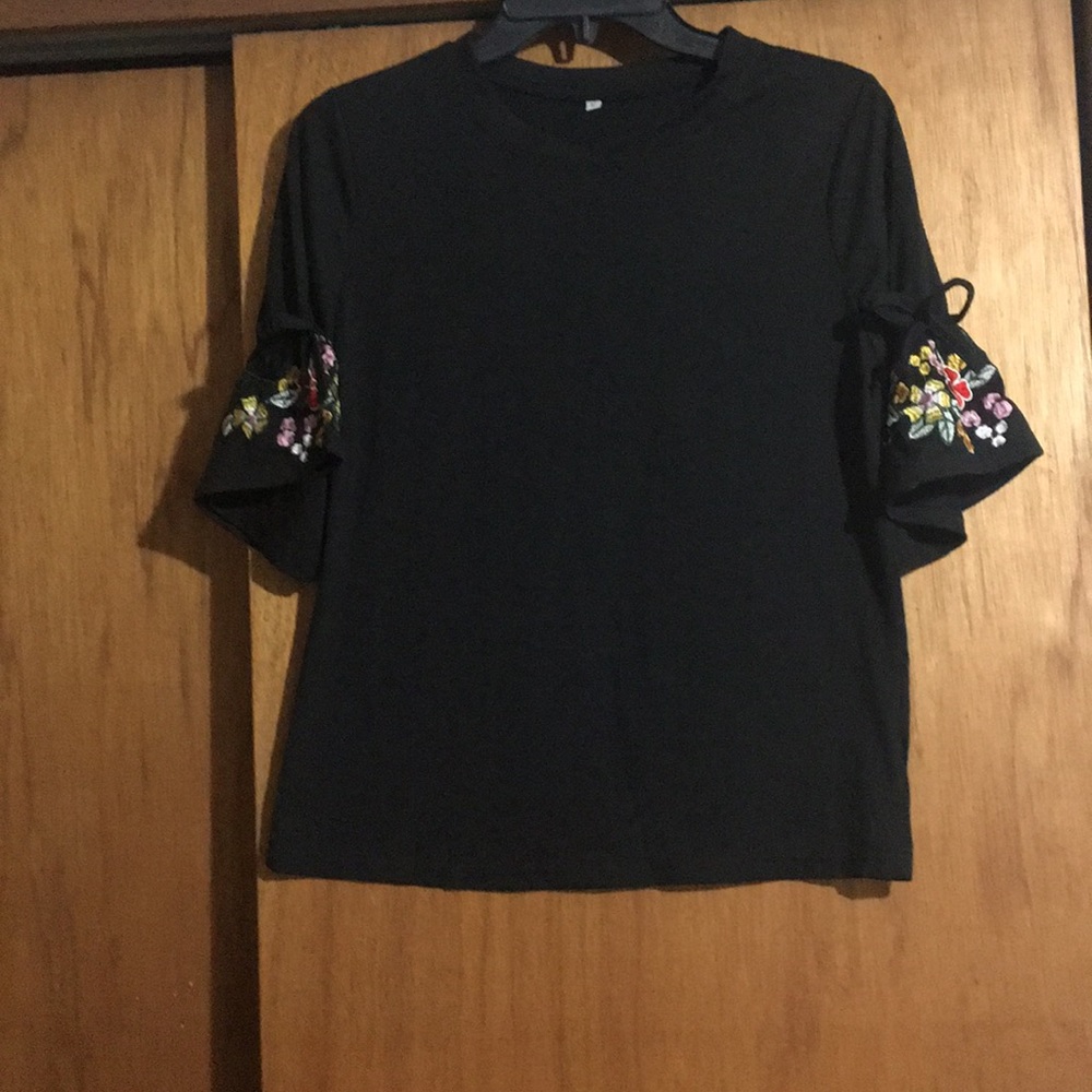 Black shirt with embroidered flower on bell sleeve